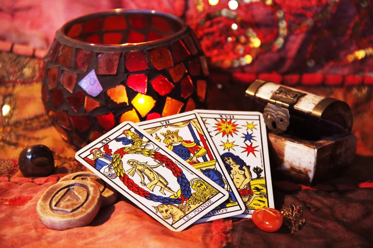 Tarot cards laid out beside a candle and small chest