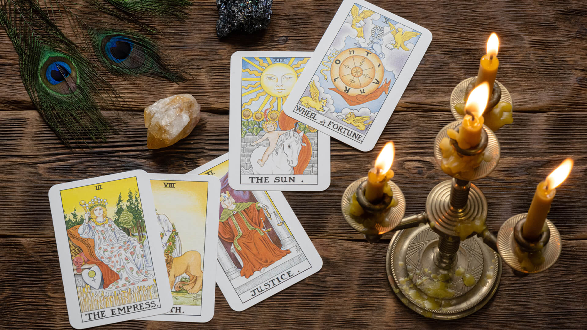 Tarot cards and candle arranged on a wooden table